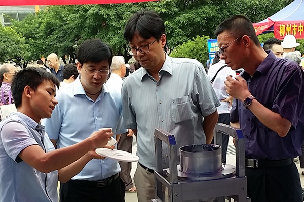 学生向柳州市安卫副市长、柳州市科技局孙松局长介绍硬币分类清点包装一体机.jpg
