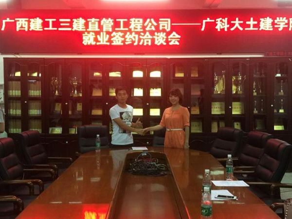 图为土建学院学生全创雄与三建直管工程公司党委副书记莫莉签署三方协议