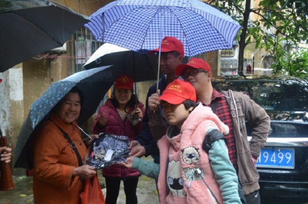 图为志愿者为老人送棉衣