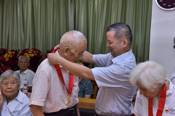 学校党委常委、副校长、组织部部长张发钦同志为“光荣在党50年”的老党员颁发纪念章、政治生日卡、鲜花和慰问金 (2).JPG