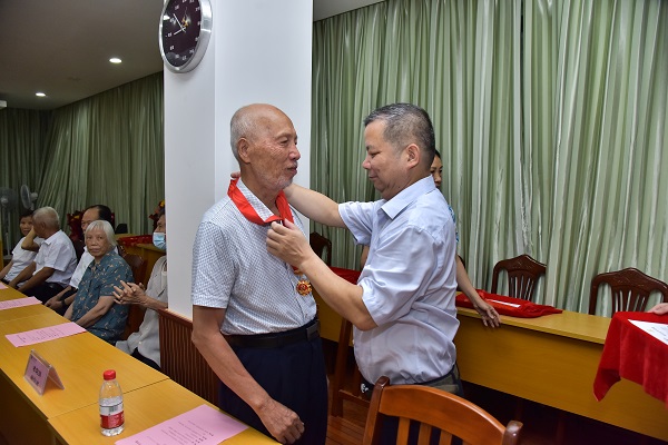 学校党委常委、副校长、组织部部长张发钦同志为15名“光荣在党50年”的老党员颁发纪念章、政治生日卡、鲜花和慰问金.JPG