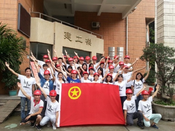 土建学子戴着安全帽与团旗合影